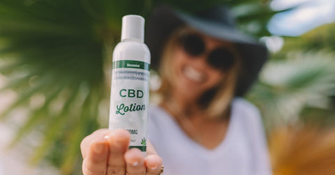 Mujer sosteniendo un frasco de producto de CBD
