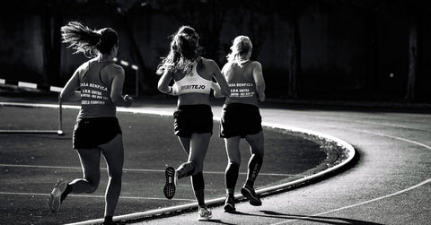 Atletas corriendo en una pista de atletismo en un estadio