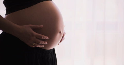 Mujer embarazada sosteniendo su vientre con las manos