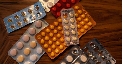 Diversas pastillas y cápsulas de medicamentos sobre una mesa